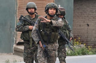 Indian soldiers walk along a street in Wuyan near Indian-administered Kashmir's main city of Srinagar after a loud explosion was heard on May 7, 2025